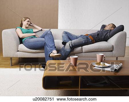 Stock Image - Young couple talking on sofa. Fotosearch