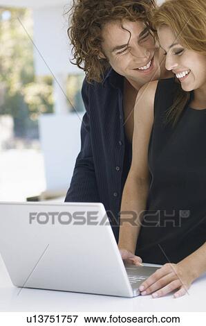 Young couple using laptop View Large Photo Image Stock Photo - Young couple using laptop. Fotosearch