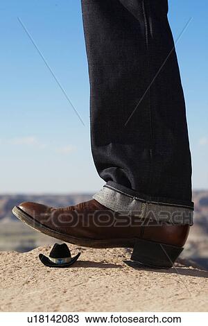 Cowboy boot treading miniature Stetson View Large Photo Image Stock Image - Cowboy boot treading miniature Stetson. Fotosearch