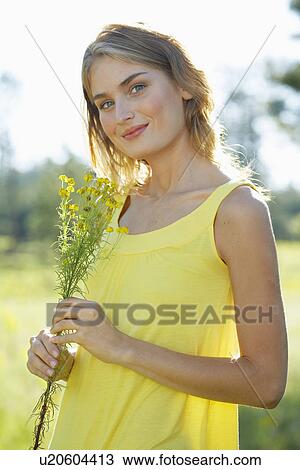 Portrait of young woman with a wildflower View Large Photo Image Stock Image - Portrait of young woman with a wildflower. Fotosearch