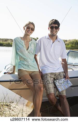 Young couple leaning on motorboat View Large Photo Image Picture - Young couple leaning on motorboat. Fotosearch