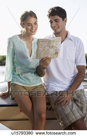Stock Image - Young couple looking at map. Fotosearch