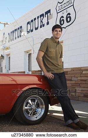 Young man leaning on car by motel, Arizona, USA View Large Photo Image Stock Image - Young man leaning on car by motel, Arizona, USA. Fotosearch