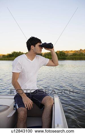 Young man using binoculars at lake View Large Photo Image Stock Image - Young man using binoculars at lake. Fotosearch
