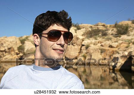 Stock Image - Young man with sunglasses. Fotosearch