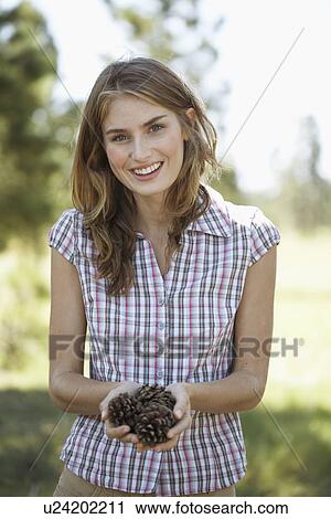 Young woman holding pine cones View Large Photo Image Stock Image - Young woman holding pine cones. Fotosearch