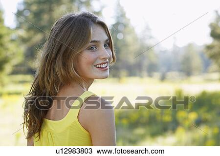Stock Image - Young woman in field. Fotosearch