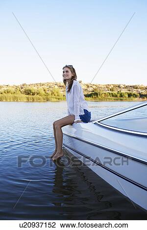 Stock Image - Young woman sitting at the edge of motorboat, Arizona, USA. Fotosearch