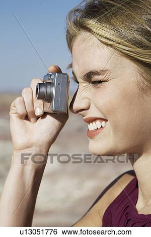 Stock Photograph - Young woman taking a photograph. Fotosearch
