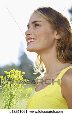 Stock Image - Young woman with a wildflower. Fotosearch