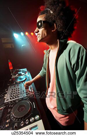 Disk jockey playing records at nightclub View Large Photo Image Picture - Disk jockey playing records at nightclub. Fotosearch
