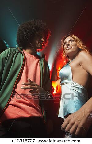 Young couple dancing at nightclub (low angle view) View Large Photo Image Stock Photo - Young couple dancing at nightclub (low angle view). Fotosearch