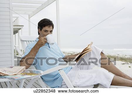 Mid adult man reading newspaper and drinking coffee View Large Photo Image Stock Photo - Mid adult man reading newspaper and drinking coffee. Fotosearch