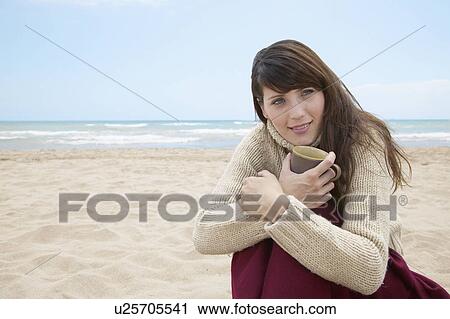 Stock Image - Mid-Adult Woman with Book on Beach. Fotosearch