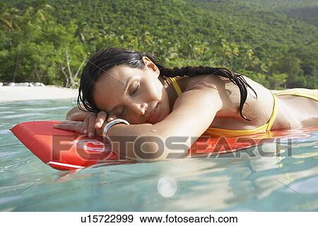 Young woman floating on bodyboard near beach View Large Photo Image Stock Photo - Young woman floating on bodyboard near beach. Fotosearch