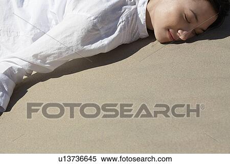Young woman lying on sand View Large Photo Image Stock Photography - Young woman lying on sand. Fotosearch