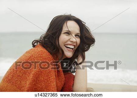 Stock Photography - Young woman wrapped in towel, laughing. Fotosearch