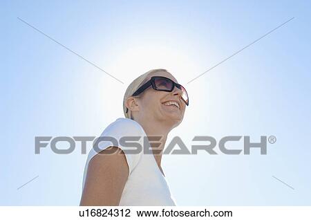Mature woman wearing sunglasses (low angle view) View Large Photo Image Stock Image - Mature woman wearing sunglasses (low angle view). Fotosearch