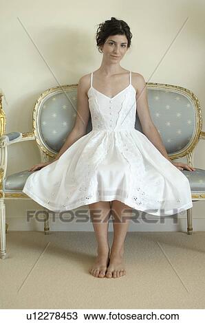 Young woman in white dress sitting on chair (portrait) View Large Photo Image Stock Image - Young woman in white dress sitting on chair (portrait). Fotosearch