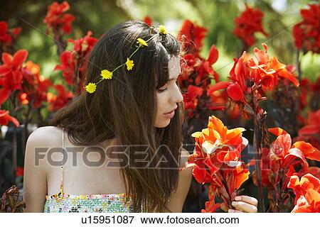 Young woman smelling red flowers View Large Photo Image Stock Photo - Young woman smelling red flowers. Fotosearch