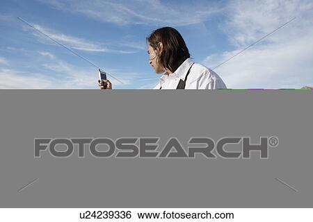 Businessman using cell phone in desert View Large Photo Image Stock Photograph - Businessman using cell phone in desert. Fotosearch