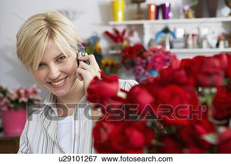 Female florist on cell phone View Large Photo Image Stock Photo - Female florist on cell phone. Fotosearch