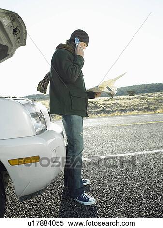 Mid adult man with road map talking on cell phone by broken car View Large Photo Image Stock Photography - Mid adult man with road map talking on cell phone by broken car. Fotosearch