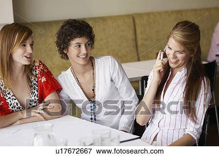 Three teenage girls with cell phone in cafe View Large Photo Image Stock Photo - Three teenage girls with cell phone in cafe. Fotosearch