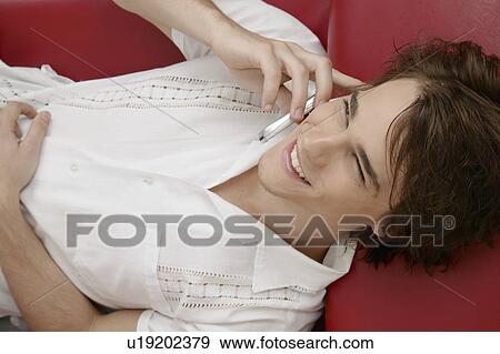 Young man talking on cell phone View Large Photo Image Stock Photo - Young man talking on cell phone. Fotosearch
