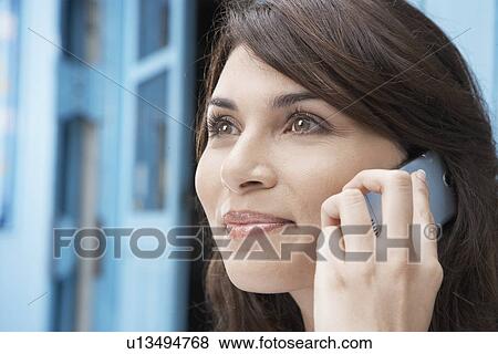 Stock Photo - Young woman on cell phone. Fotosearch