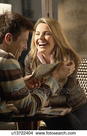 Picture - Mid adult couple looking at map in cafe. Fotosearch