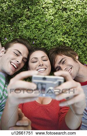 Three friends photographing themselves (directly above) View Large Photo Image Stock Image - Three friends photographing themselves (directly above). Fotosearch