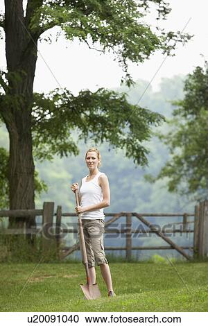 Stock Image - Gardener with spade in field. Fotosearch