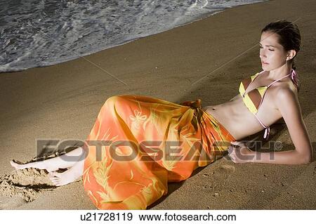 Young adult woman in bikini lying down on beach, High Angle View View Large Photo Image Stock Photo - Young adult woman in bikini lying down on beach, High Angle View. Fotosearch