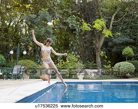 Young woman dipping toe in swimming pool View Large Photo Image Stock Photography - Young woman dipping toe in swimming pool. Fotosearch
