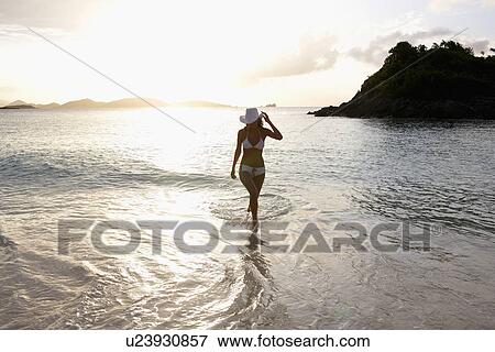 Young woman in bikini walking in ocean, St. John, US Virgin Islands, USA View Large Photo Image Stock Photo - Young woman in bikini walking in ocean, St. John, US Virgin Islands, USA. Fotosearch