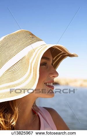 Stock Photo - Young woman in sun hat at lake. Fotosearch