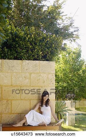 Young woman reading book outdoors (portrait) View Large Photo Image Stock Image - Young woman reading book outdoors (portrait). Fotosearch