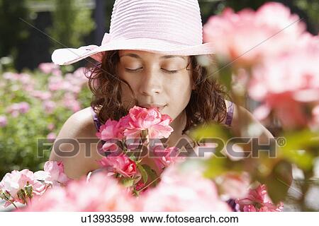 Young woman smelling flowers View Large Photo Image Stock Photo - Young woman smelling flowers. Fotosearch