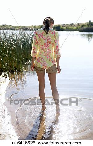 Young woman standing in lake View Large Photo Image Stock Photograph - Young woman standing in lake. Fotosearch