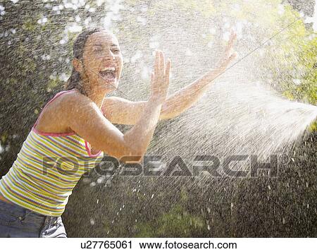 Young woman under water spray View Large Photo Image Stock Image - Young woman under water spray. Fotosearch