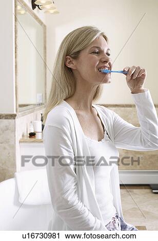 Mature woman cleaning teeth View Large Photo Image Stock Image - Mature woman cleaning teeth. Fotosearch