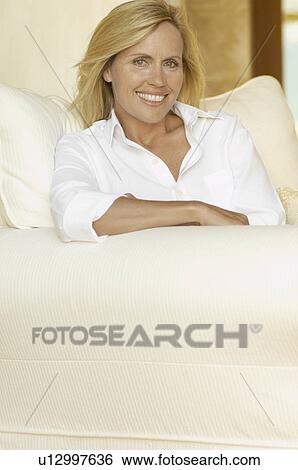 Mature woman in white shirt on armchair View Large Photo Image Stock Photograph - Mature woman in white shirt on armchair. Fotosearch