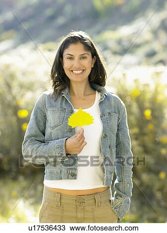 Mid adult woman holding autumnal leaf, portrait View Large Photo Image Stock Image - Mid adult woman holding autumnal leaf, portrait. Fotosearch