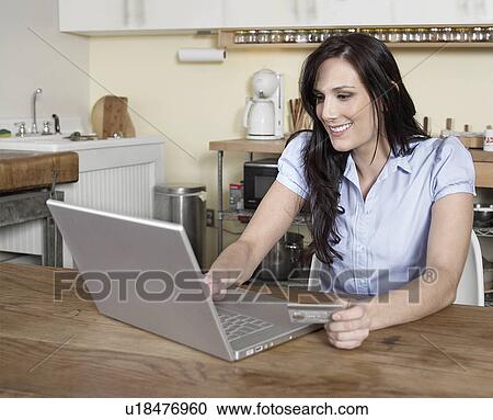Stock Image - Mid-Adult Woman Shopping Online. Fotosearch