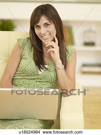 Mid-Adult Woman Using Laptop on Sofa View Large Photo Image Picture - Mid-Adult Woman Using Laptop on Sofa. Fotosearch