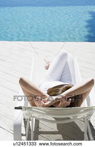 Woman lying on lounge chair (high angle view) View Large Photo Image Stock Image - Woman lying on lounge chair (high angle view). Fotosearch