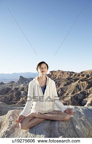 Woman meditating in lotus position in desert, Death Valley, California, USA View Large Photo Image Stock Photograph - Woman meditating in lotus position in desert, Death Valley, California, USA. Fotosearch