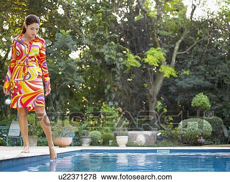 Young woman dipping toe in swimming pool View Large Photo Image Stock Photo - Young woman dipping toe in swimming pool. Fotosearch