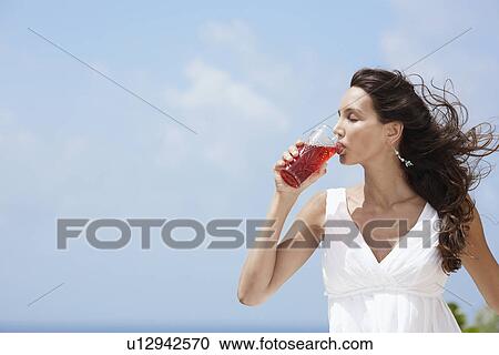 Stock Image - Young woman drinking juice. Fotosearch